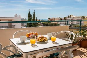 una mesa con un plato de pan y vasos de zumo de naranja en Algarve Golden Properties: Casa da Galé, en Lagos