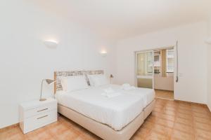 Un dormitorio blanco con una cama blanca y una ventana en Algarve Golden Properties: Casa da Galé, en Lagos