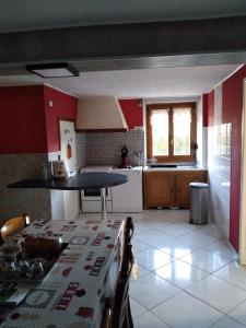 a kitchen with red walls and a white tile floor at gite chez Maise in Le Val-dʼAjol