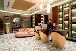 a man sitting at a desk in a room with a computer at Regal Collection House in Dương Cảnh