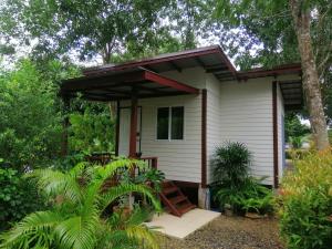 a small white house with a porch at Sameikei Homestay in Phrae