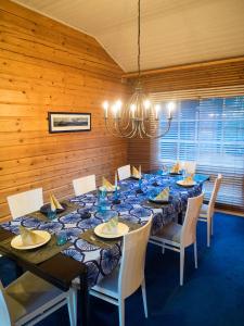 Villa Mustikka في تامساري: غرفة طعام مع طاولة طويلة مع كراسي وثريا