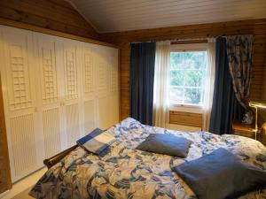 1 dormitorio con 1 cama con 2 almohadas en Villa Mustikka en Tammisaari