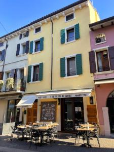 a group of tables and chairs in front of a building at La Casa in Paese in Peschiera del Garda