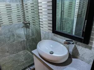 un bagno con un lavandino bianco e una doccia di Residency Hotel Lekki Phase 1 a Lekki