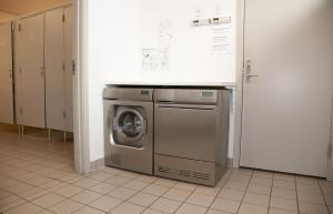 Waschmaschine und Trockner in einer Waschküche in der Unterkunft Harbour Sleep in Neksø