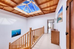 a room with a wooden staircase with a skylight at Villa Flavia-private pool, jacuzzi, sea views in Playa Blanca