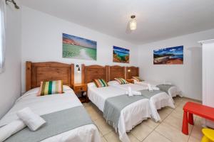 a group of four beds in a room at Villa Flavia-private pool, jacuzzi, sea views in Playa Blanca