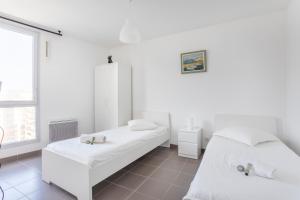 a white room with two beds and a window at NEW JOLIETTE Comfortable Apartment well located with private parking in Marseille
