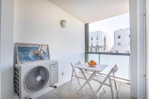 - une salle à manger avec une table et un ventilateur dans l'établissement NEW JOLIETTE Comfortable Apartment well located with private parking, à Marseille