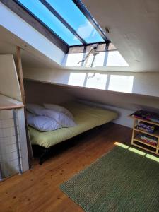 - un petit lit dans une chambre avec fenêtre dans l'établissement L'Escapade 3 étoiles, à Champagne-sur-Seine