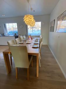 un comedor con una mesa larga y sillas en Golden Circle private Farmhouse with hot tub, en Selfoss