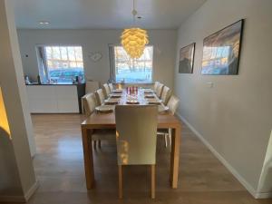 a dining room with a long table and chairs at Golden Circle private Farmhouse with hot tub in Selfoss