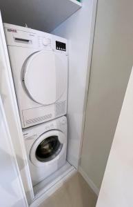 - un lave-linge et un sèche-linge dans une petite pièce dans l'établissement Apartamento Arquillo de la Plata, à Séville