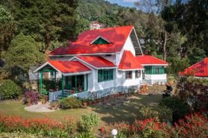 a house with a red roof and a garden at amã Stays & Trails - Wayside Villa, Kurseong in Karsiyang