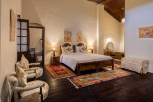 a bedroom with a bed and a chair at amã Stays & Trails - Wayside Villa, Kurseong in Karsiyang