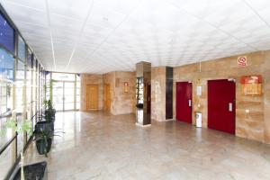 un gran vestíbulo con puertas rojas en un edificio en AQUAMARINA A HomeStay By Turismar, en La Pineda