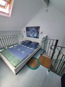 a bedroom with a bed with a blue comforter at Gîte Milly - 2 studios en coeur de ville in Milly-la-Forêt