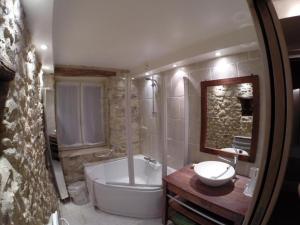 a bathroom with a tub and a toilet and a sink at Gîte Milly - 2 studios en coeur de ville in Milly-la-Forêt