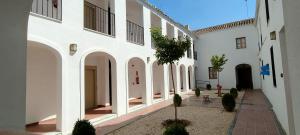 a courtyard of a building with white walls at La Jⲟya de los Patios - Apartamentos Turísticos in Córdoba