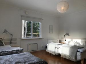 a white room with two beds and a window at Sågverket Höga Kusten in Rö