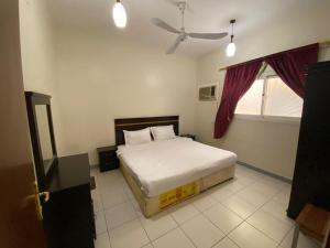 鋁哈達的住宿－منتجع وردة الهدا，一间卧室配有一张床和吊扇