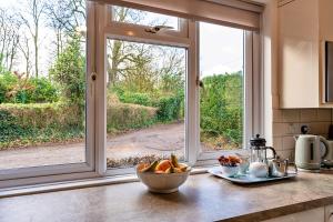 a kitchen counter with a bowl of fruit in front of a window at Finest Retreats - Glebe Cottage in Wellington