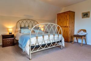 a bedroom with a metal bed and a wooden cabinet at Finest Retreats - Glebe Cottage in Wellington