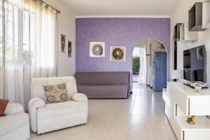 sala de estar con paredes de color púrpura y sofá en Villa Lucia, en Ognina