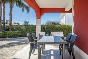 a dining table and chairs on a patio at Villa Lucia in Ognina