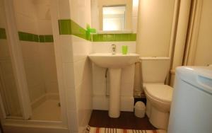 a white bathroom with a sink and a toilet at Studio near UNESCO - Invalides in Paris