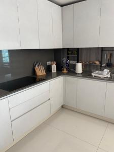 a kitchen with white cabinets and black counter tops at Luxury Penthouse, Nilaveli in Trincomalee