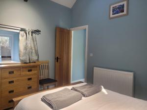 1 dormitorio con 1 cama, vestidor y ventana en The Bakery, en Llanddeiniol