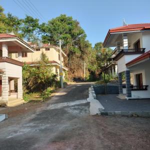 an empty road between two houses in a village at Guruvayoor Homestay in Trichūr