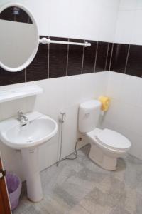 La salle de bains est pourvue d'un lavabo, de toilettes et d'un miroir. dans l'établissement โคบาล ห้องพักรายวัน, à Chom Thong