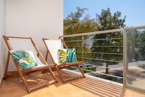 ラゴスにあるSea La Vie Beach & Golf Apartmentの大きな窓のあるバルコニーに椅子が備わります。