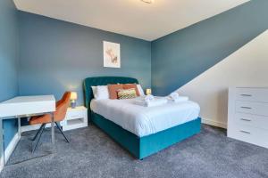 ein blaues Schlafzimmer mit einem Bett und einem Schreibtisch in der Unterkunft #Upmarket, Exceptional 4 bed house, with free parking, close to KFc McDonald ALDI Dominos and centre in Sheffield