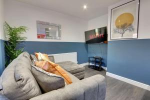 a living room with a couch and a tv at #Upmarket, Exceptional 4 bed house, with free parking, close to KFc McDonald ALDI and centre in Sheffield