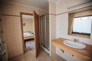 uma casa de banho com um lavatório, um chuveiro e uma janela. em L'Aurore des Hautes Fagnes 30 pers- Malmedy, vue exceptionnelle, wellness em Malmedy