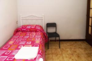 uma cama e uma cadeira num pequeno quarto em B&B Porta Roma em Capua