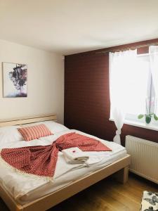 a bedroom with a bed with a red blanket on it at Ubytovanie MI - TATRY in Kravany