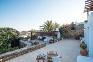 a backyard with a stone wall and a patio at Traditional Cycladic House 2 in Mykonos in Mykonos