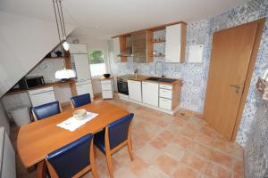 a kitchen with a wooden table and blue chairs at Ferienwohnung Zum Königsmoor 65336 in Moormerland