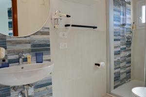 a bathroom with a sink and a mirror at Onda Su Onda Appartamenti in Seccheto