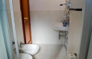 a small bathroom with a toilet and a sink at Onda Su Onda Appartamenti in Seccheto