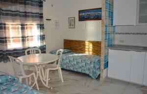 a small room with a table and chairs and a bed at Onda Su Onda Appartamenti in Seccheto