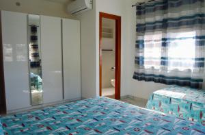 a bedroom with a bed with a blue comforter at Onda Su Onda Appartamenti in Seccheto