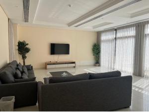 a living room with two couches and a flat screen tv at 3 Bed rooms Villa at Mina Alfajer Resort Dibba - Al-Fujairah in Rūl Ḑadnā