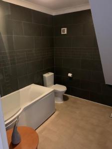 ein Bad mit einer Badewanne und einem WC in der Unterkunft Gracellie Hotel in Shanklin