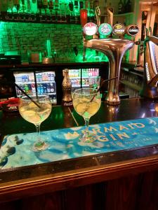 zwei Weingläser auf einer Bar in der Unterkunft Gracellie Hotel in Shanklin
